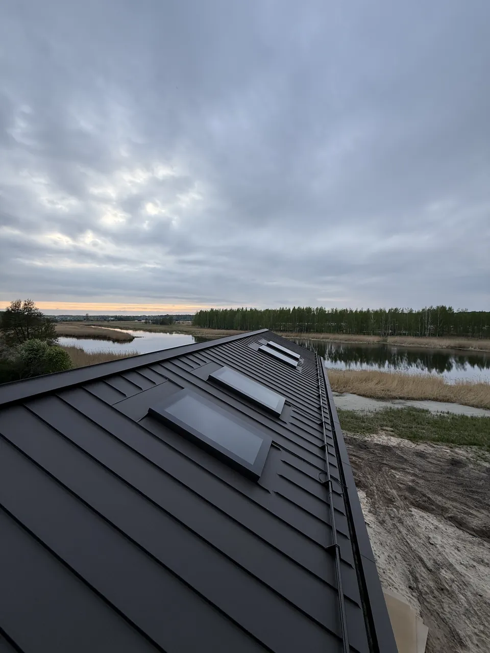 Mitu katuseakent metallkatusel vee ja puude lähedal